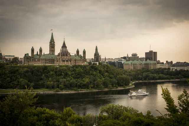 Un ciel sombre et nuageux au-dessus de la rivière en regardant la Colline du Parlement