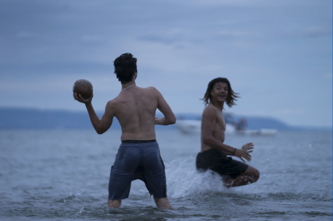 Two men playing football in the water.