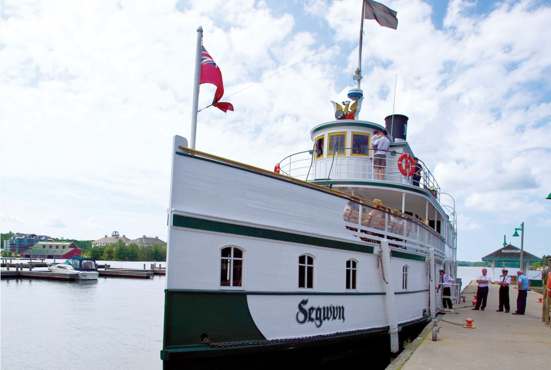 Front view of the Segwun Steamship docked, while the crew is boarding