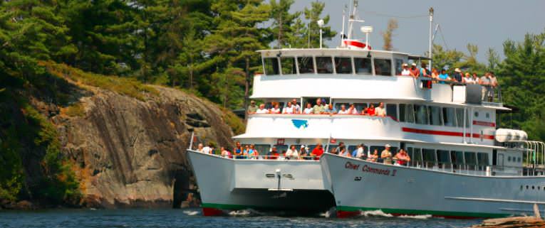 People are on a three deck ferry viewing the natural landscape.