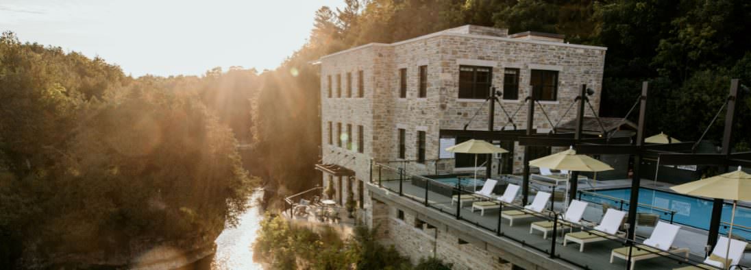 Perché au sommet des gorges d'Elora, un grand bâtiment en pierre avec un patio plein de chaises longues et de parasols