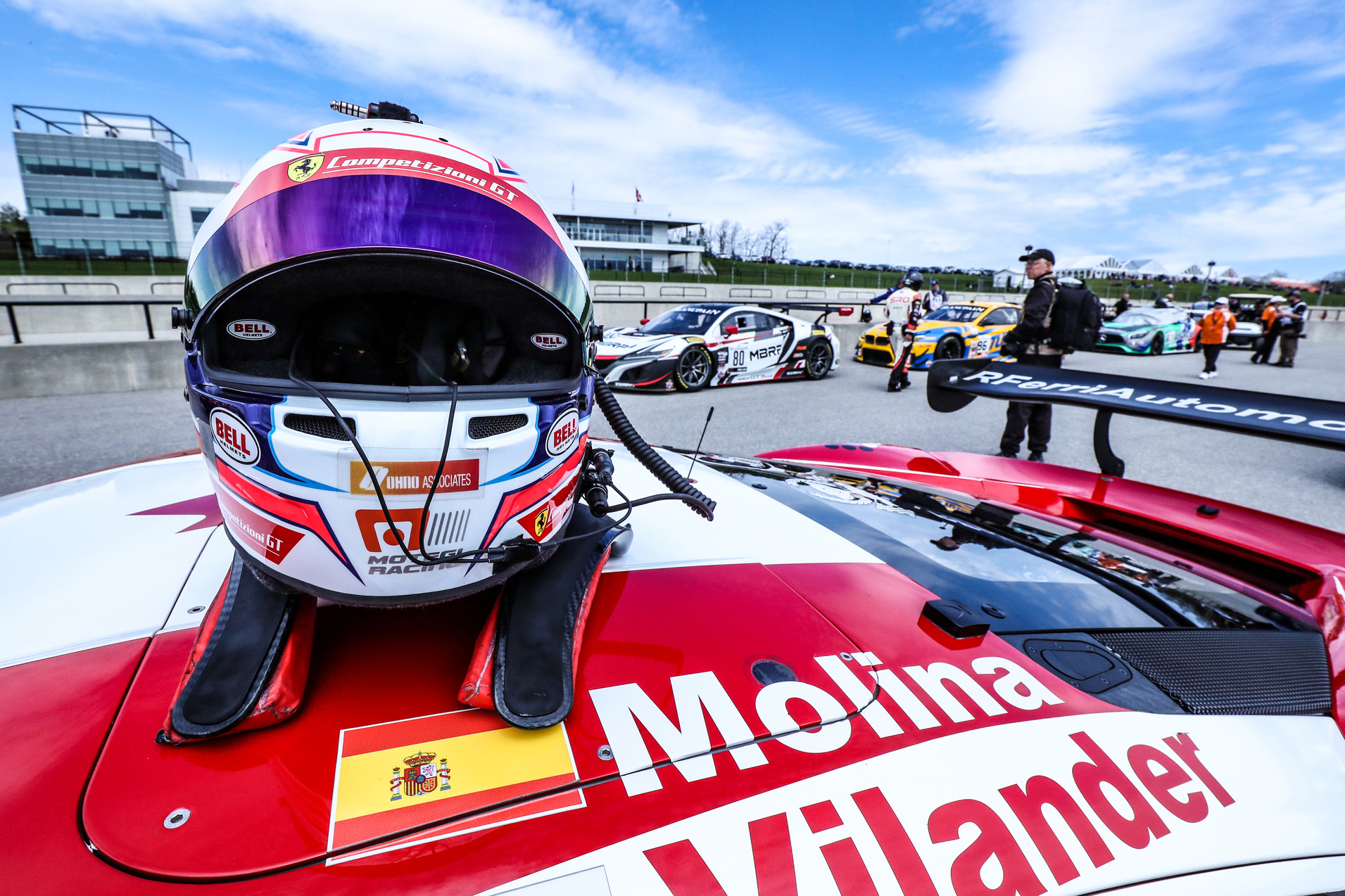 Un casque de course automobile déposé sur le dessus d’une voiture de course.