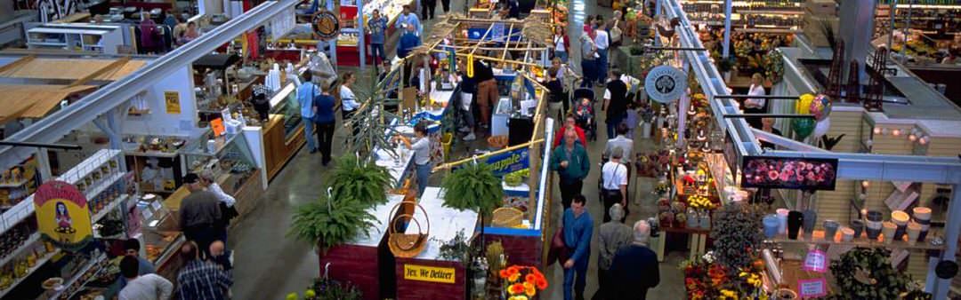 Covent Garden Market has isles people buying of food and household items.