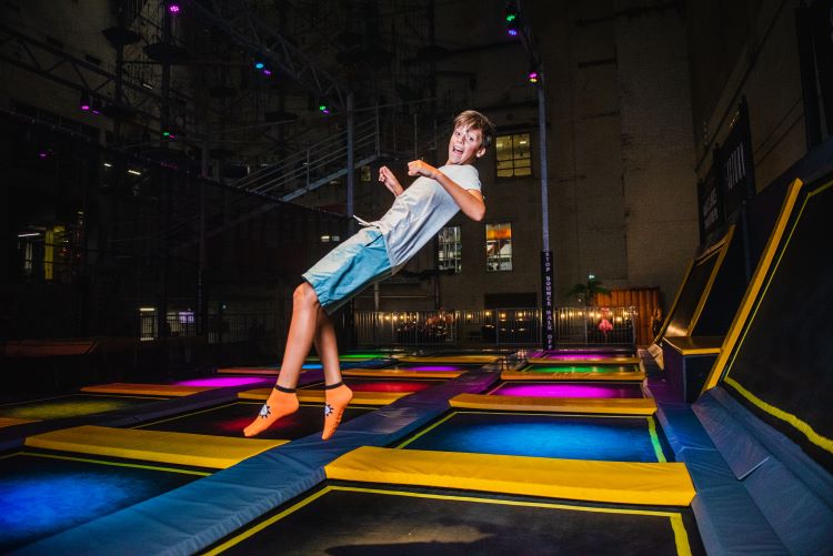 A boy jumping on a trampoline.