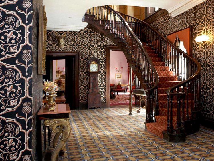 A decorative foyer and winding staircase in a heritage home.