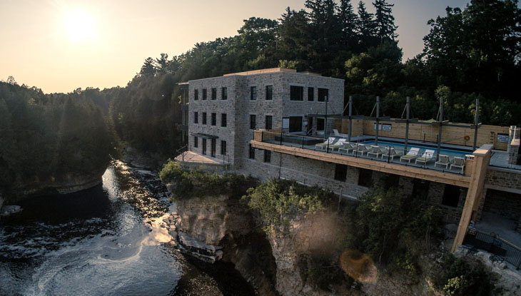 Un edificio en la cima de una colina junto a un río.