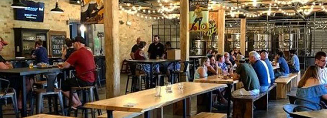 Men and women sitting at tables eating and drinking in a pub