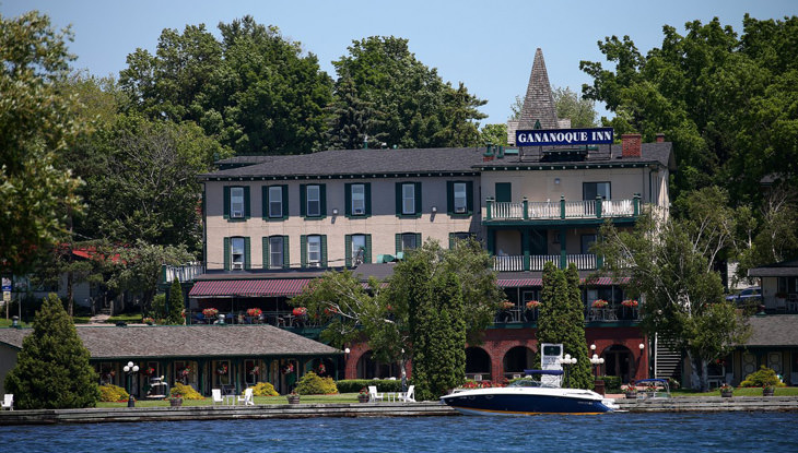 A large body of water in front of a large inn which is located on the shore.