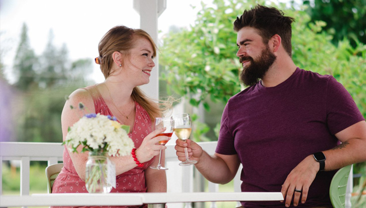 A man and a woman enjoying wine in a vineyard