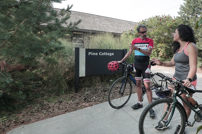 A man and woman with bicycles stop to chat