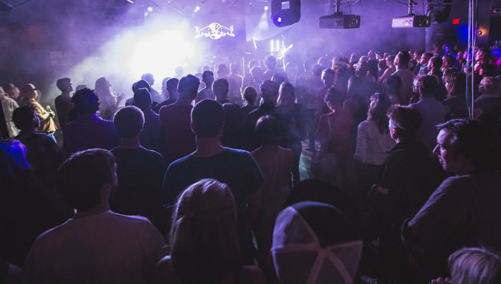 A large audience watches a band play at a concert.