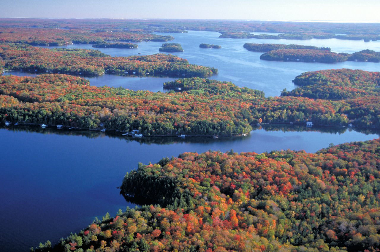 Aerial view of a collection of autumn coloured islands surround by a still waterway