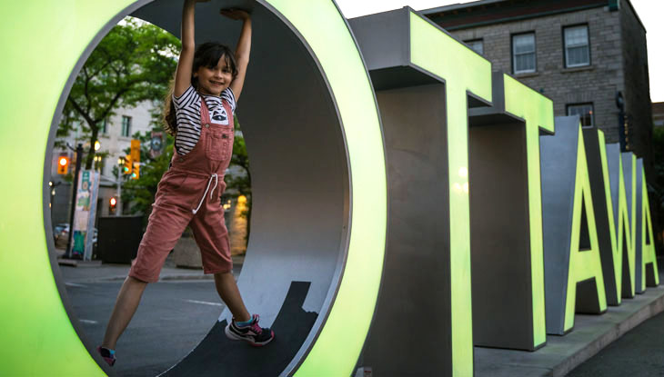 A young girl plays on the Ottawa sign in the ByWard Market.