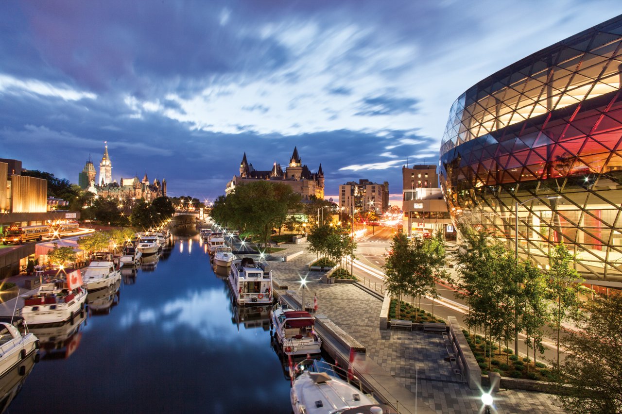 Canal Rideau al anochecer con los edificios circundantes brillando en la luz del atardecer.