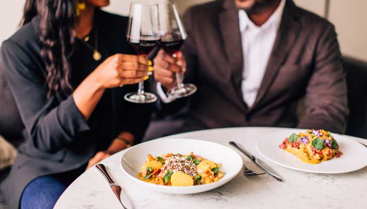 A couple making a toast to a delicious meal