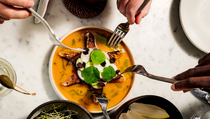 Four people share a dish at Quetzal Toronto, a MICHELIN-starred restaurant.