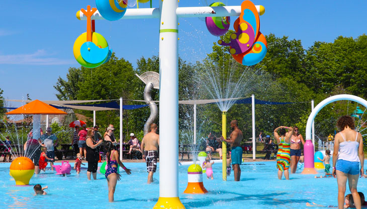 Families with young children enjoy playing in a splash pad during the summer.