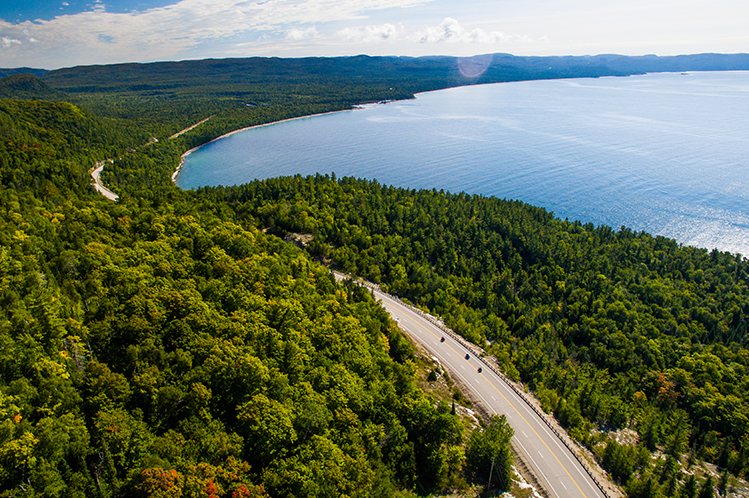 Luftaufnahme des Highway 17, der durch den Wald neben dem Lake Superior führt.