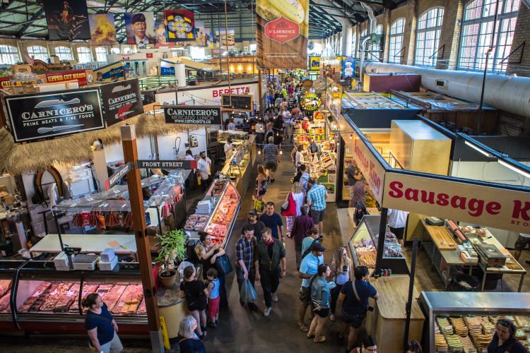 Overhead photo of a group of people walking around a market.