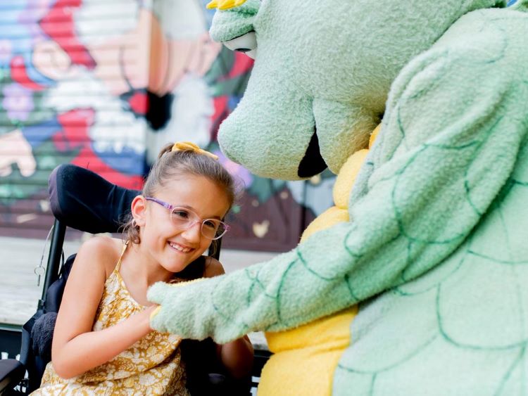 Une jeune fille s’amuse en la compagnie d’une mascotte de conte de fée.