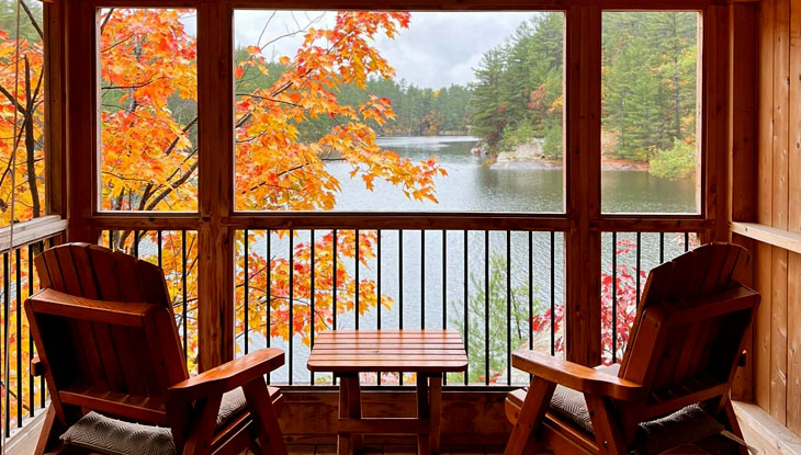 Two empty chairs facing a calm lake