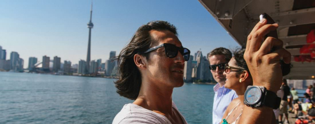 A man takes a selfie on a boat cruise overlooking the Toronto.