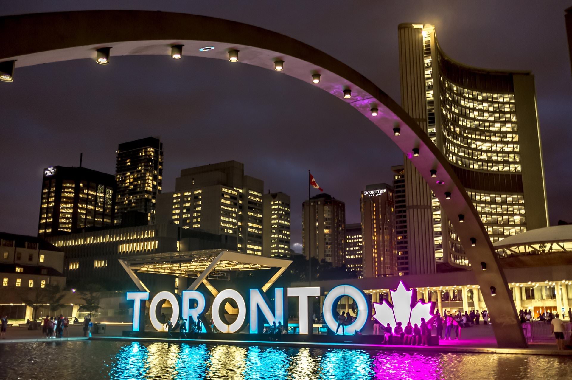 El cartel de Toronto iluminado por la noche con el resplandor de los edificios circundantes