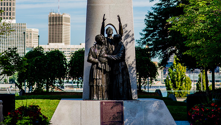 A statue featuring three people expressing their happiness