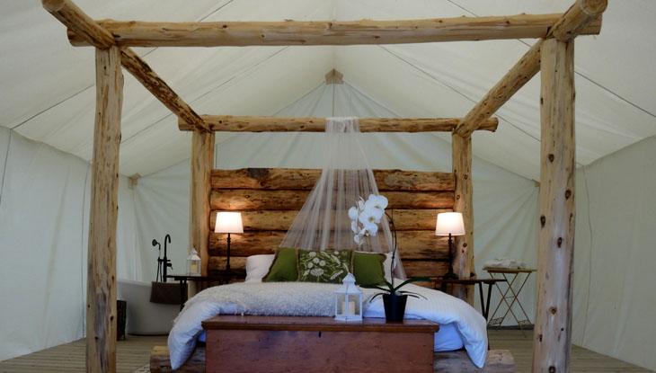 An empty bed in a luxurious and rustic setting